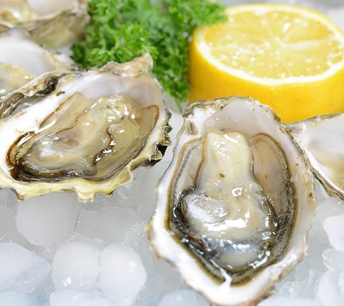 An example of serving oysters with lemon and greens, photo by Gourmet Food Store
