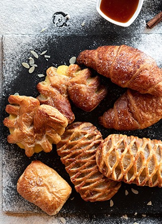  croissants and pastries on a black slate board